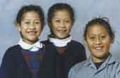 Photo shows three happy pacific Island children in school uniform. 