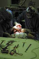 Photo shows a child being born by caesarian.