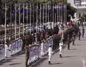 Photo of military personnel on parade at parliament grounds. 