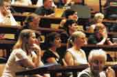 Photo shows group of university students in a lecture theatre. 