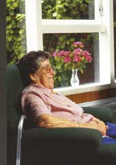 Photo shows a senior citizen relaxing in an armchair. 