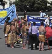 Photo shows pacific island people protesting outside parliament. 