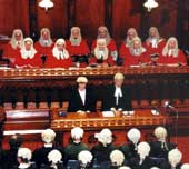 Photo shows red-robed judges at the swearing in of new barristers. 