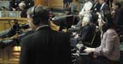 Photo shows journalists with headphones listening to parliament's speakers.