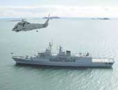 Photo shows the naval vessel Te Kaha with a helicopter hovering over it. 